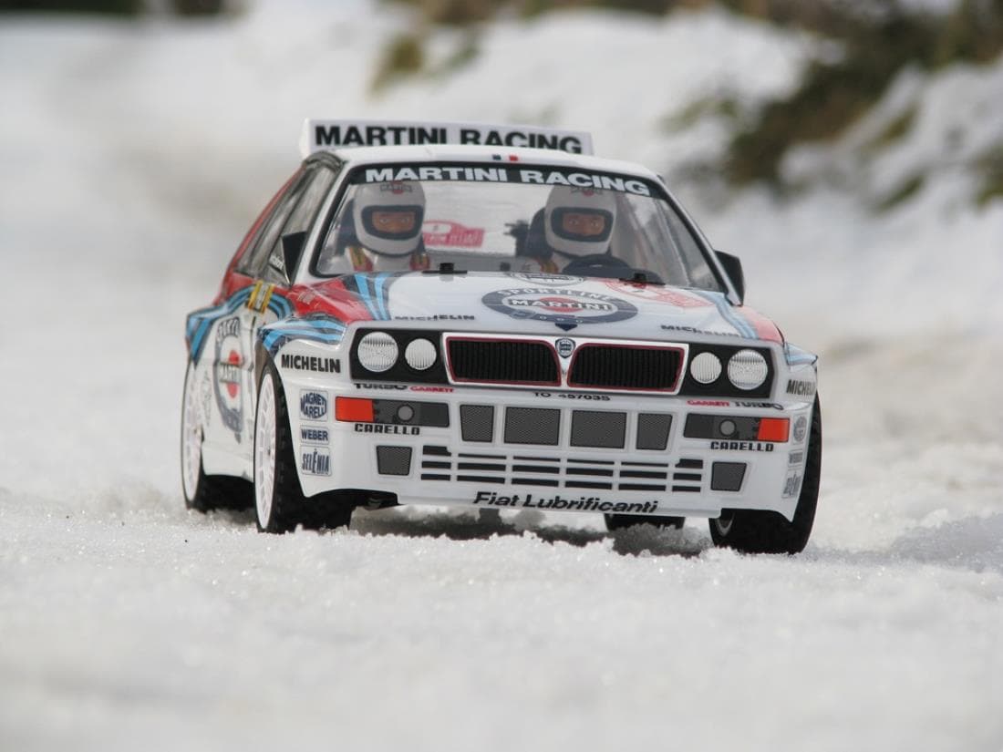 Lancia Delta S4 rouge en action sur spéciale rallye, terre et gravier