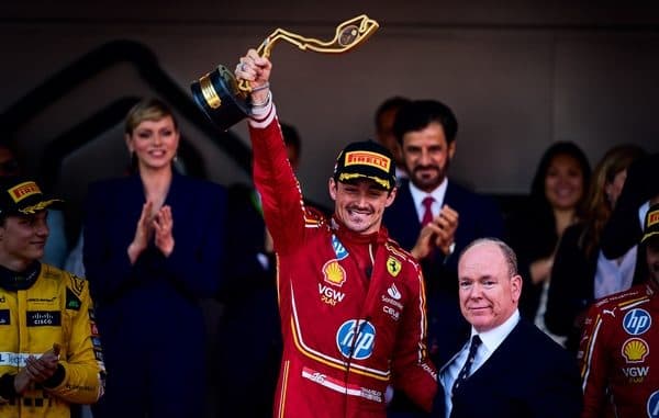 Charles Leclerc sur le podium en Ferrari, casque rouge et blanc